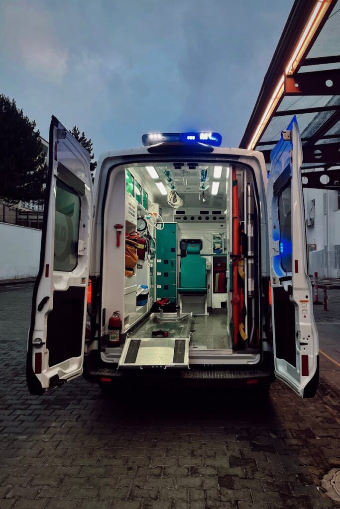 Open ambulance with visible interior in parking area during evening